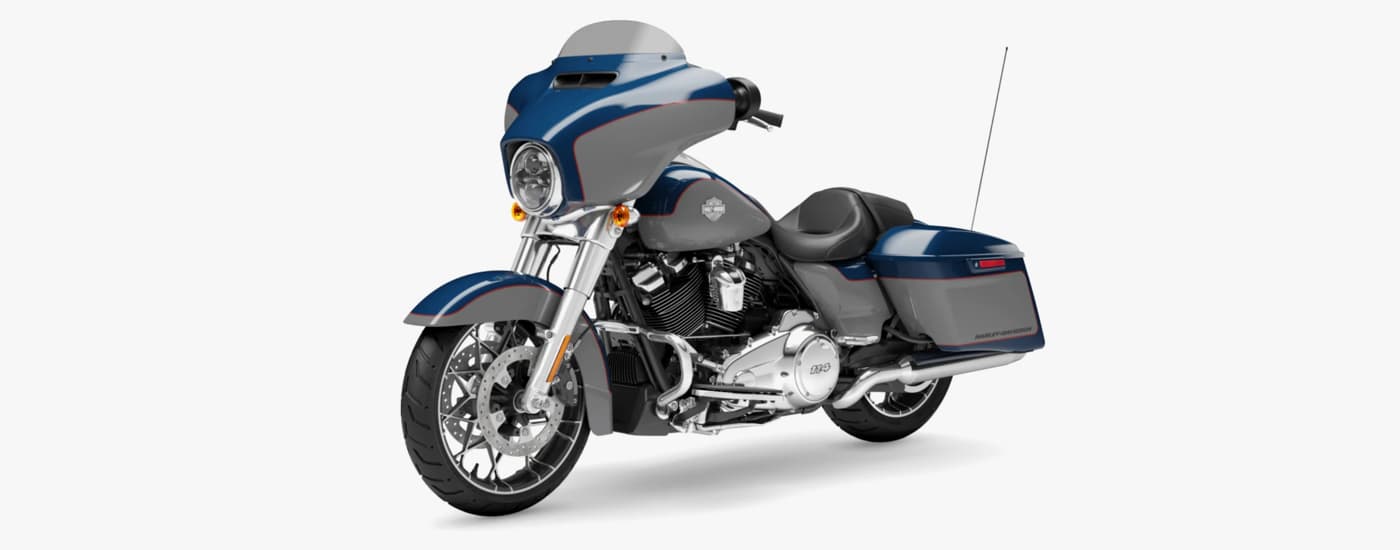 A blue and white 2023 Harley-Davidson Street Glide is shown angled left.
