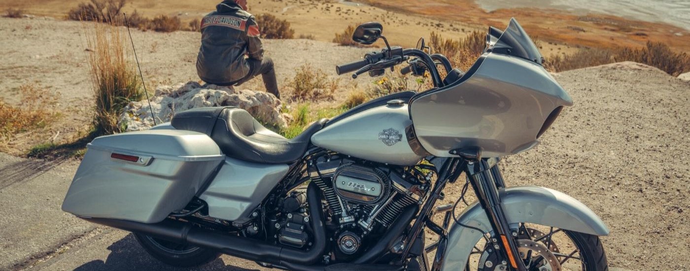 A person is shown sitting next to a silver 2022 Harley-Davidson Road Glide Special.