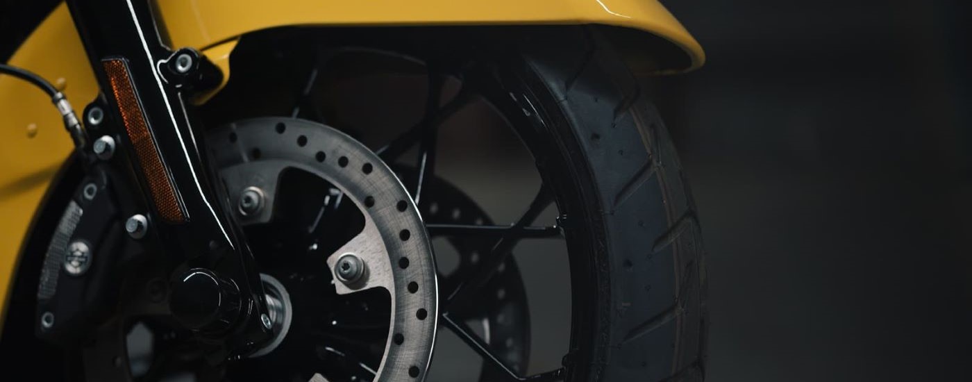 A close up shows the wheel on a yellow 2021 Harley-Davidson Road King Special.