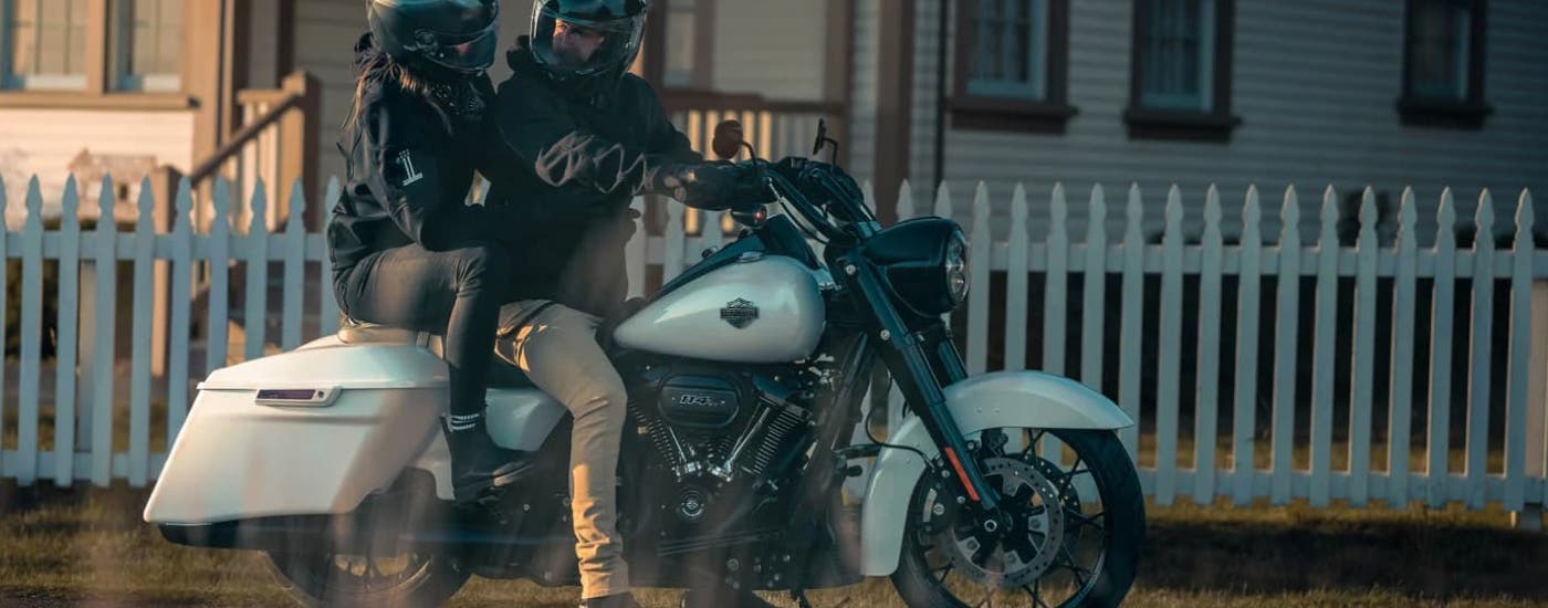 Two people are riding on a white 2024 Harley-Davidson Road King Special.