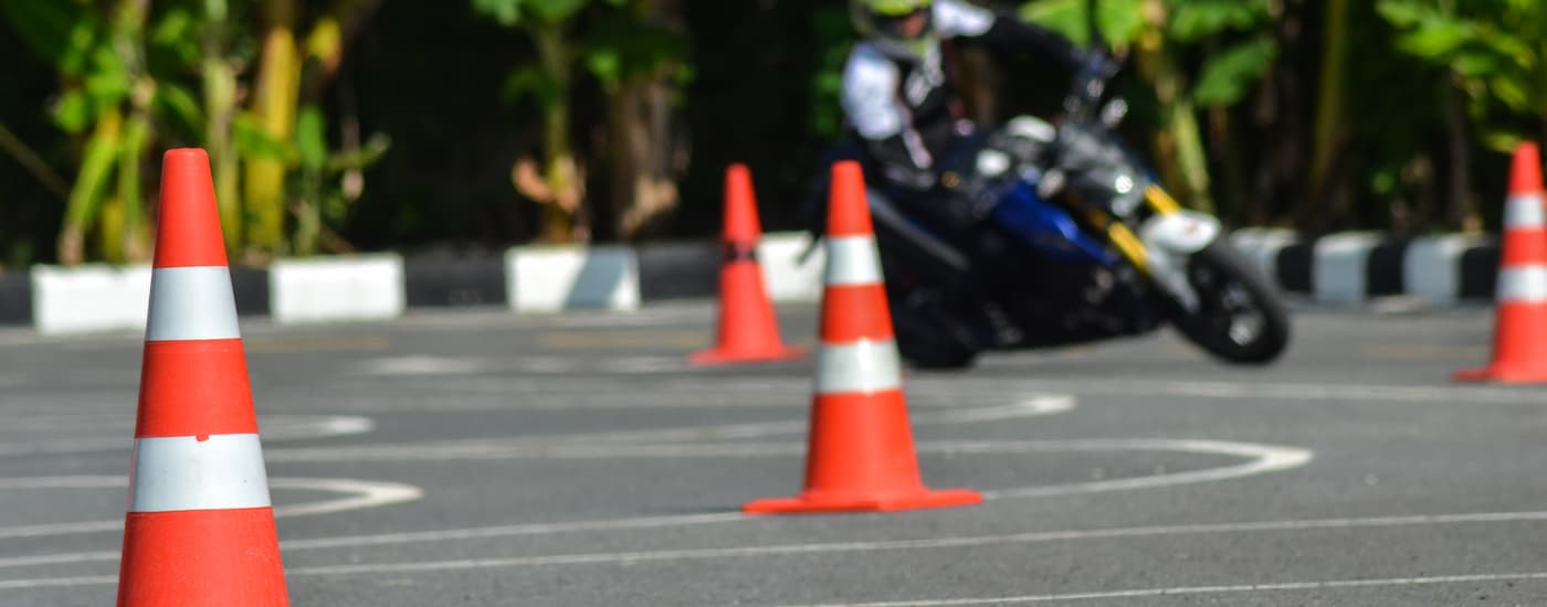 A motorcyclist is shown taking a beginner training course.