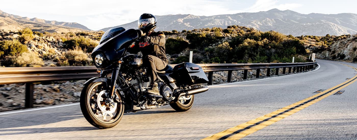 A black 2022 Harley-Davidson Street Glide ST is shown on an open road after leaving a Katy …