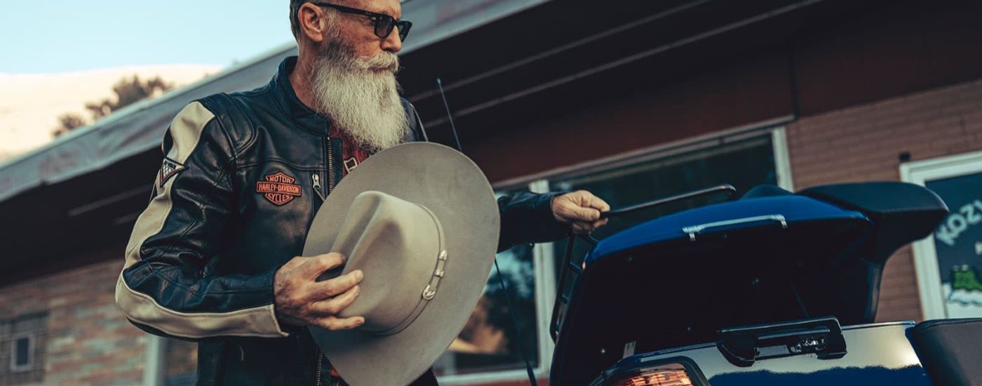 A person with a cowboy hat is shown near a 2023 Harley-Davidson Road Glide Limited.